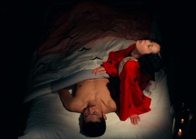 un homme nu sous un drap de soie avec une femme en kimono rouge, vue de haut
