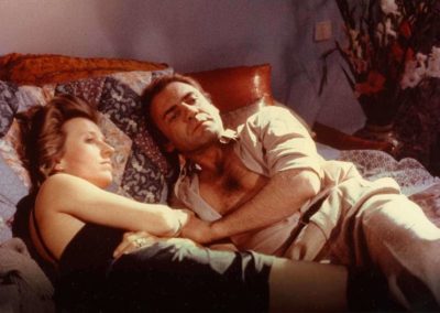 une femme et un homme habillé et couché sur un lit