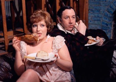 Andréa Féréol et Philippe Noiret qui mangent, assis dans un canapé.