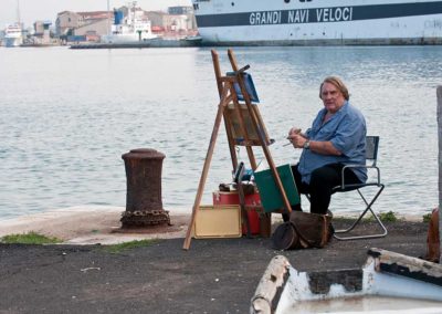 Gérard Depardieu devant un chevalet de peintre, sur un port