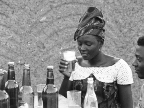 Femme africaine qui déguste une bière.