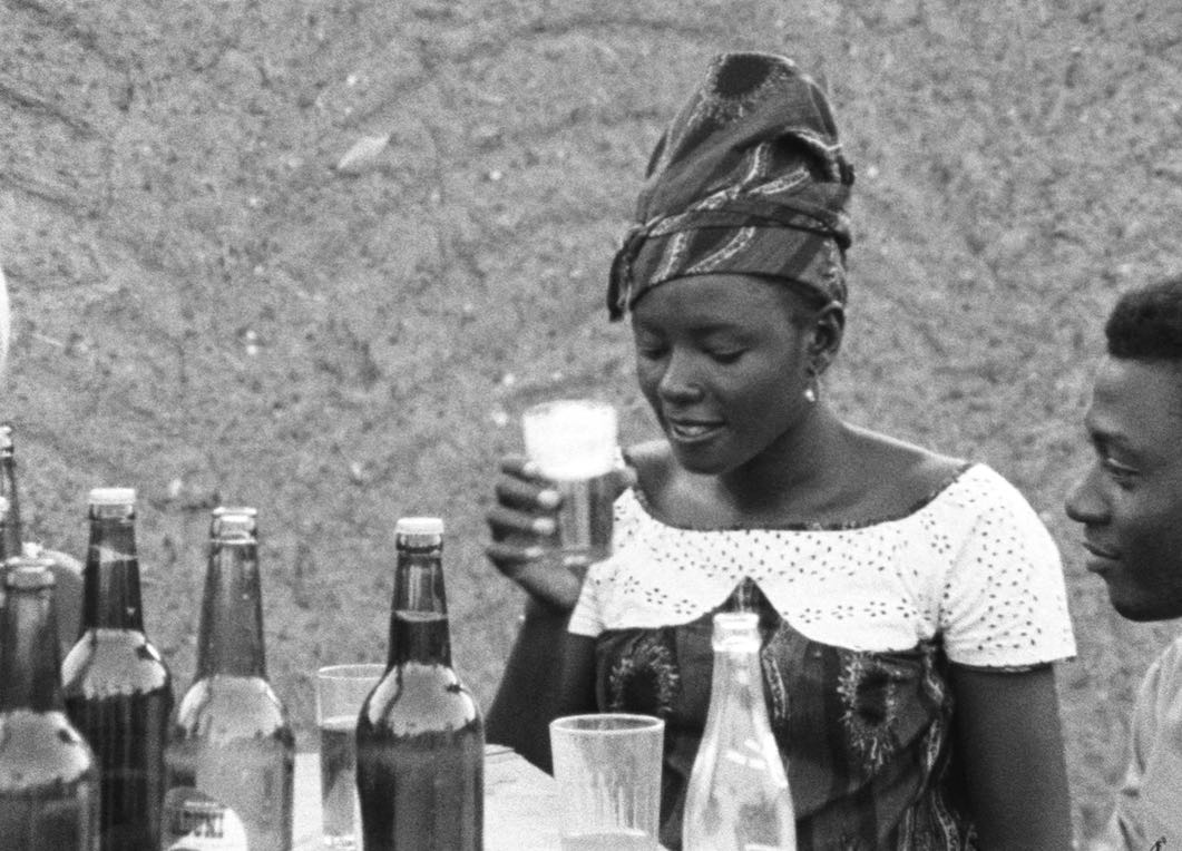 Femme africaine qui déguste une bière.