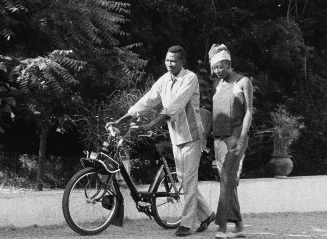 Homme qui pousse un vélo accompagné d'une femme